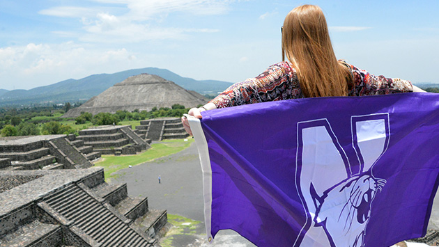 Student with Wildcat flag at a temple in Furuya, Mexico